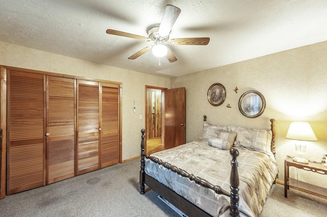 carpeted bedroom with ceiling fan, a textured ceiling, and a closet