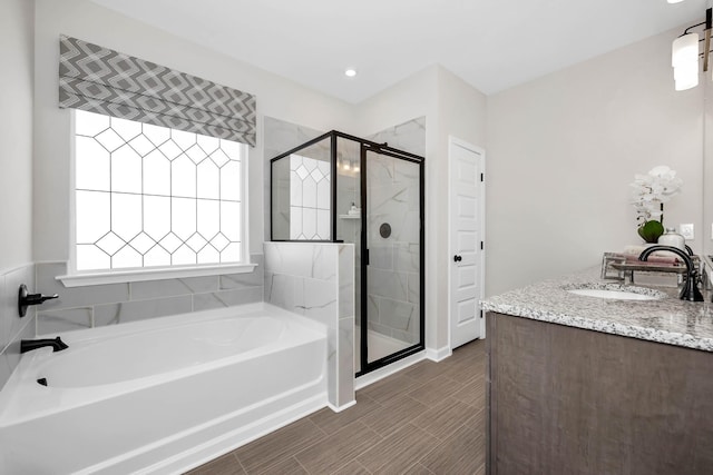 bathroom with double vanity, a stall shower, a sink, and a bath