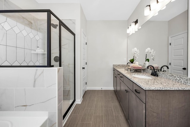 bathroom with a stall shower, vanity, and baseboards