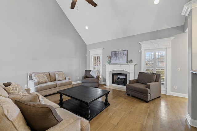 living room featuring ceiling fan, high vaulted ceiling, and light hardwood / wood-style floors