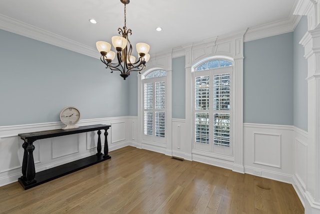 entrance foyer with ornamental molding, a chandelier, and light hardwood / wood-style floors