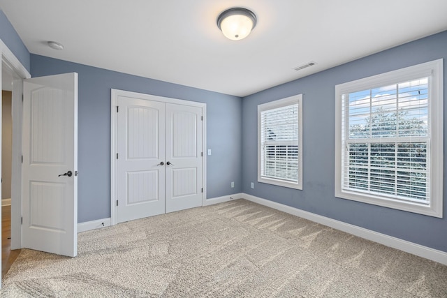 unfurnished bedroom featuring carpet flooring and a closet