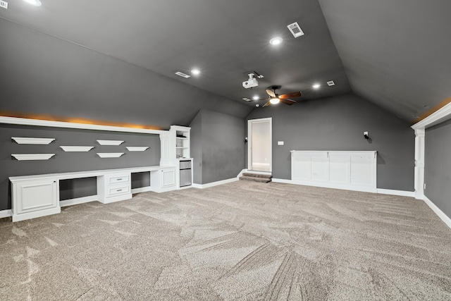 interior space featuring lofted ceiling, carpet floors, and built in desk