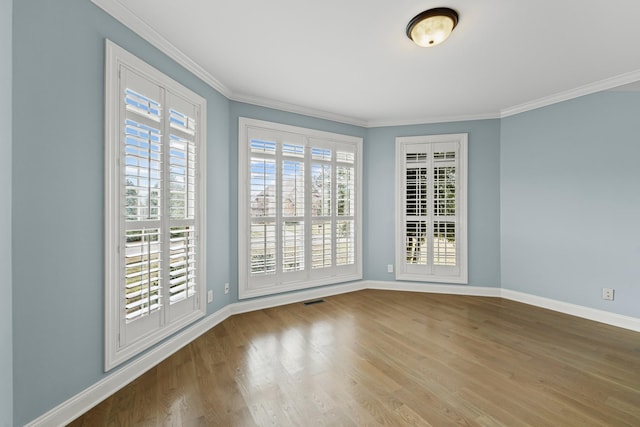 empty room featuring ornamental molding and wood-type flooring