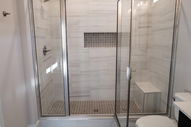 bathroom featuring vanity, toilet, and an enclosed shower