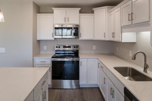 kitchen with stainless steel appliances, sink, white cabinets, and dark hardwood / wood-style flooring