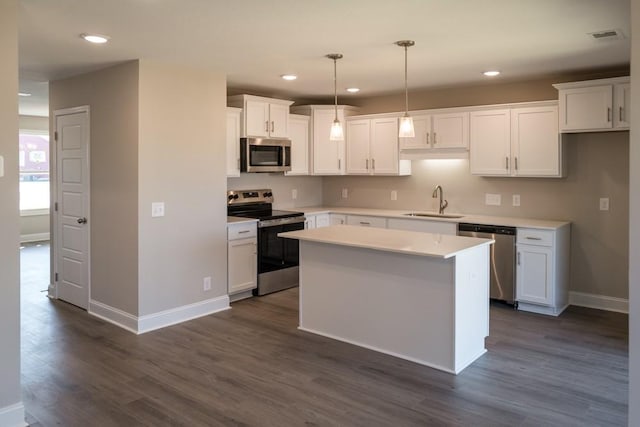 kitchen with white cabinetry, stainless steel appliances, a center island, and pendant lighting