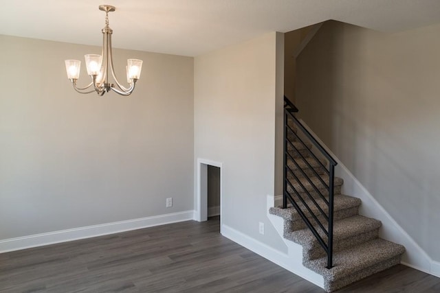 stairway with an inviting chandelier and wood-type flooring