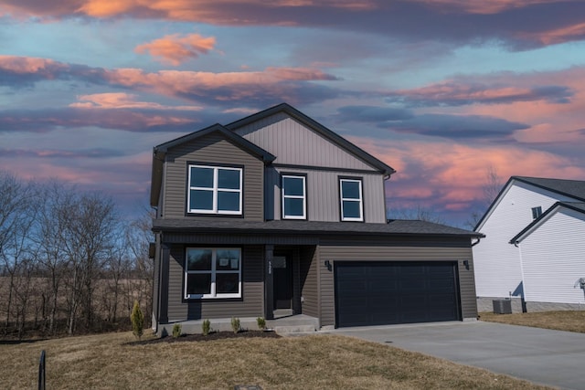 view of front facade with central AC, a garage, and a lawn