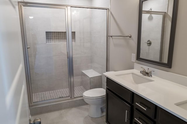 bathroom featuring vanity, toilet, an enclosed shower, and tile patterned flooring