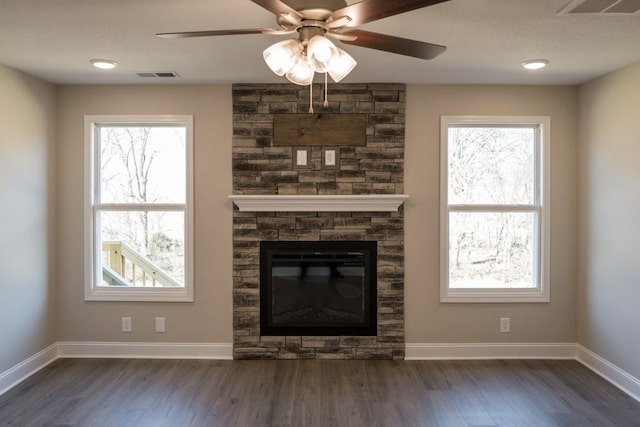 unfurnished living room with ceiling fan, a fireplace, and dark hardwood / wood-style flooring