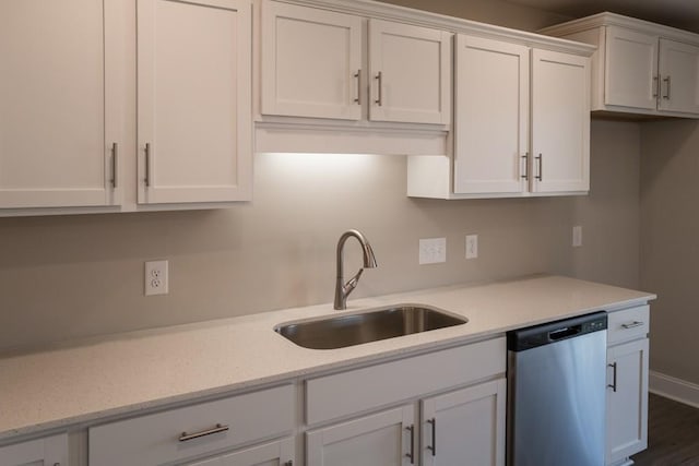 kitchen with white cabinetry, dishwasher, sink, and light stone countertops