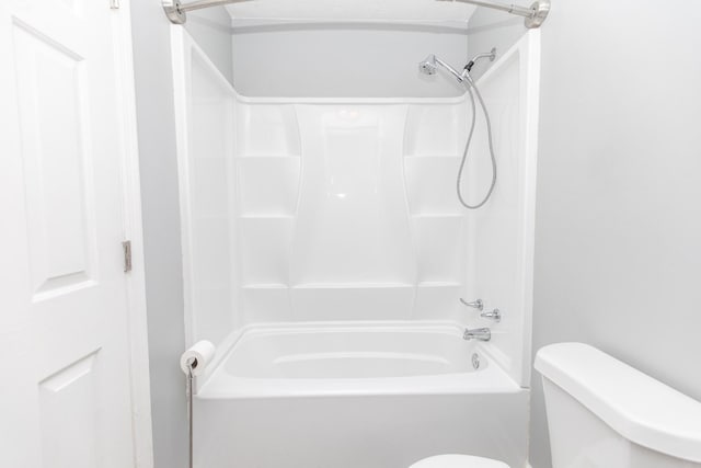 bathroom featuring shower / washtub combination and toilet