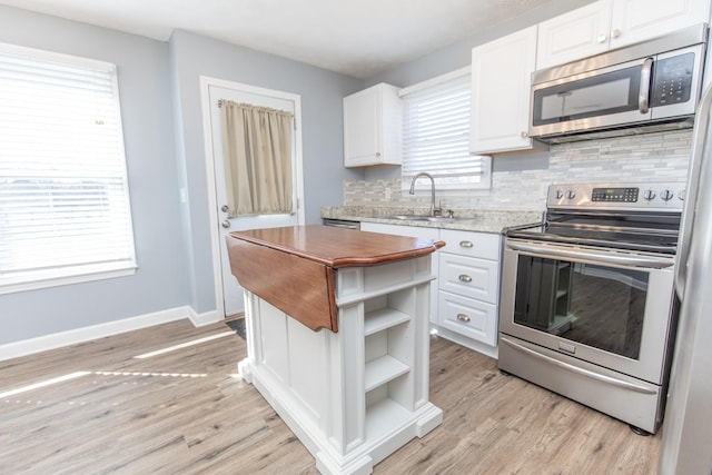 kitchen featuring stainless steel appliances, sink, white cabinets, and backsplash