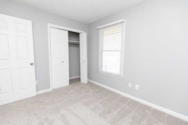 unfurnished bedroom with carpet floors, a closet, and a textured ceiling