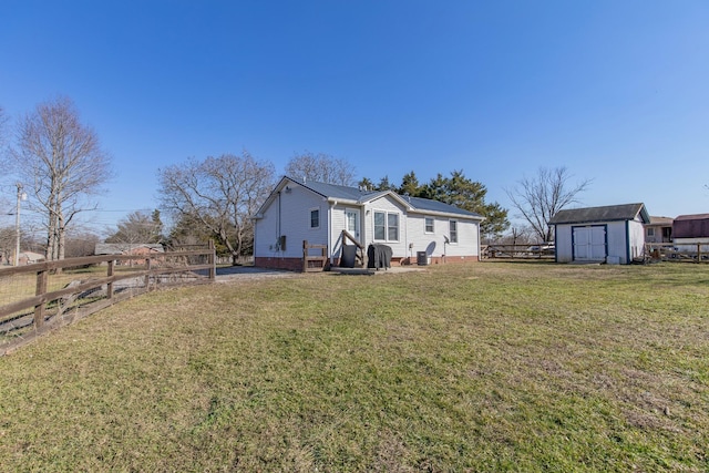 rear view of house featuring a storage shed and a lawn