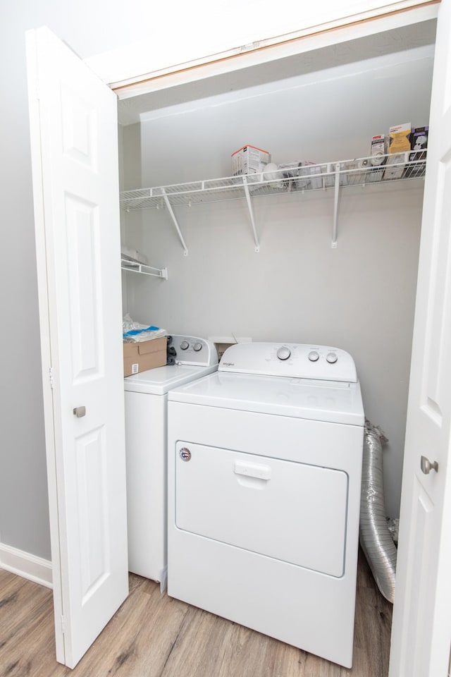 laundry area featuring washer and dryer and light hardwood / wood-style floors