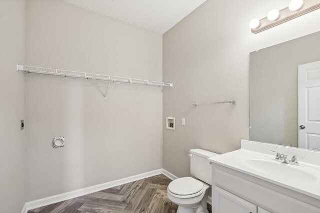 bathroom featuring vanity, toilet, and baseboards