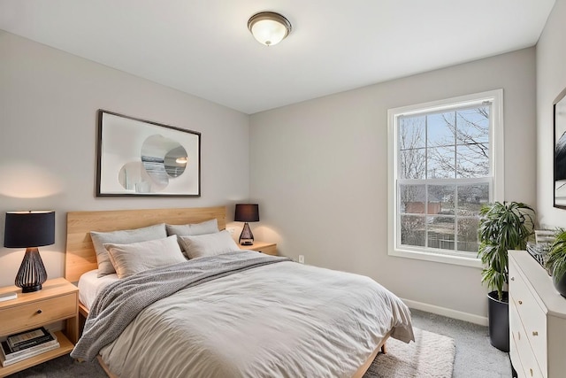 bedroom featuring light colored carpet and baseboards