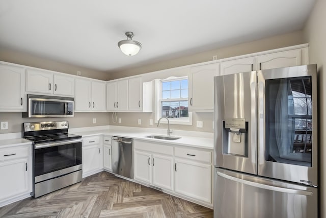 kitchen with white cabinetry, appliances with stainless steel finishes, light countertops, and a sink