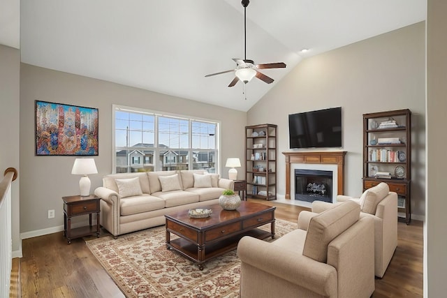 living room with ceiling fan, vaulted ceiling, and wood-type flooring