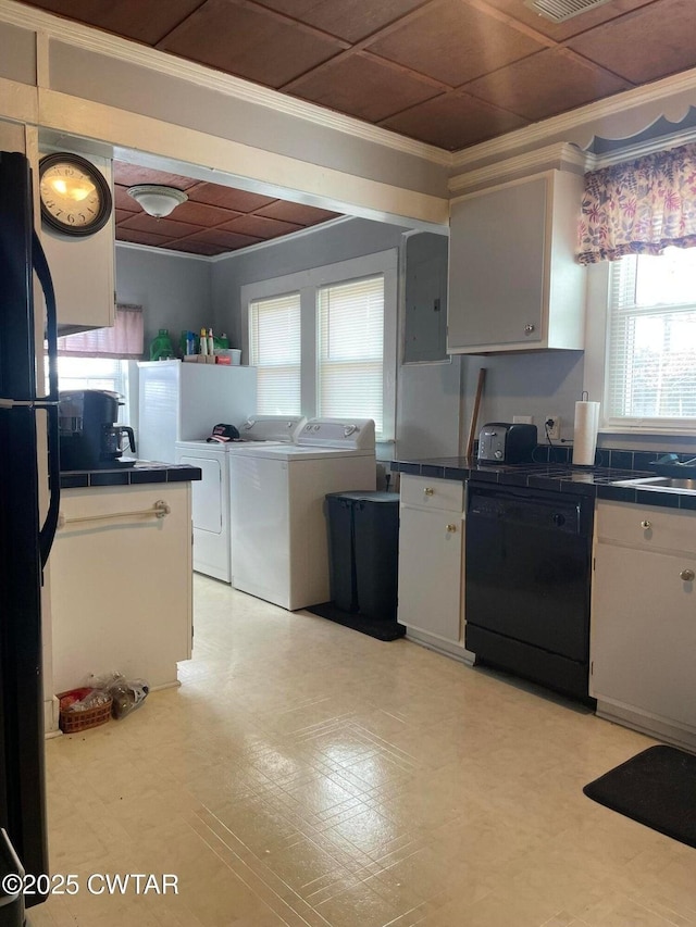 kitchen with crown molding, white cabinetry, electric panel, black appliances, and washing machine and clothes dryer