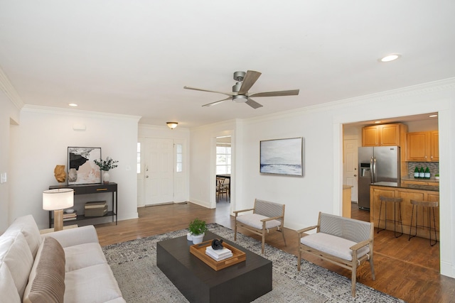 living room with ornamental molding, dark wood-type flooring, and ceiling fan