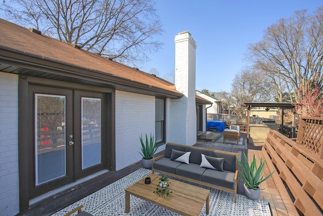 wooden terrace with outdoor lounge area and french doors