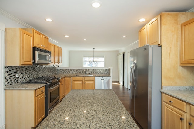 kitchen with hanging light fixtures, appliances with stainless steel finishes, sink, and light stone countertops