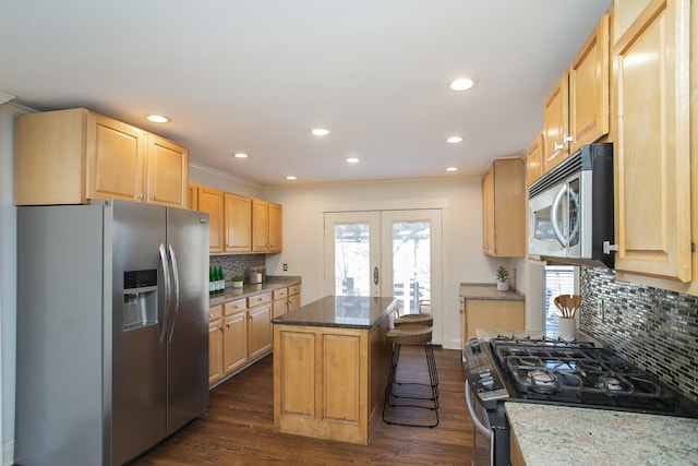 kitchen featuring a breakfast bar area, stainless steel appliances, dark hardwood / wood-style floors, a center island, and light stone countertops