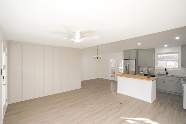 kitchen featuring stainless steel fridge, wooden counters, a healthy amount of sunlight, and gray cabinets