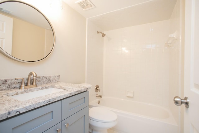 full bathroom featuring tiled shower / bath, vanity, and toilet