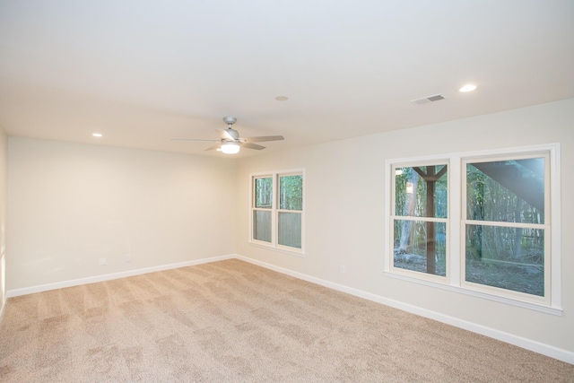 spare room with light colored carpet and ceiling fan