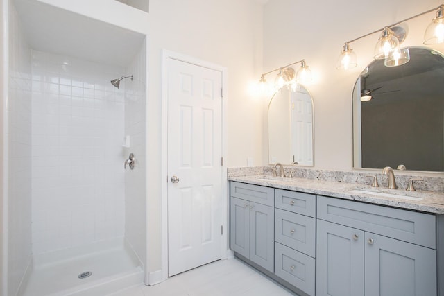 bathroom with vanity and a tile shower