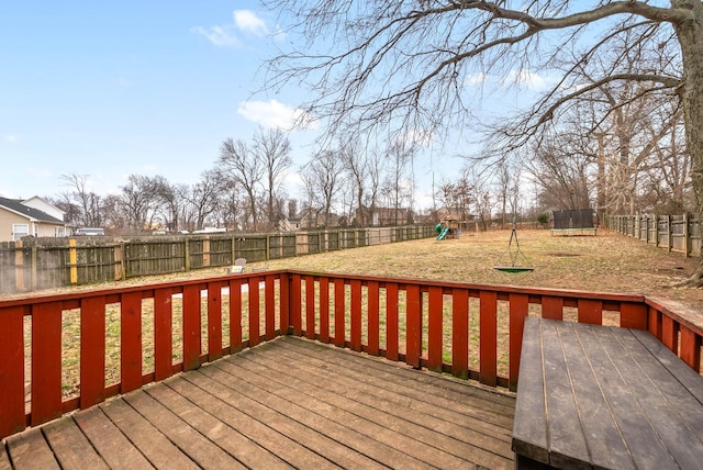 deck with a trampoline, a yard, and a playground