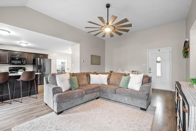 living room featuring lofted ceiling and light hardwood / wood-style floors