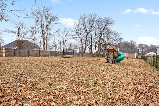 view of yard with a playground and a trampoline