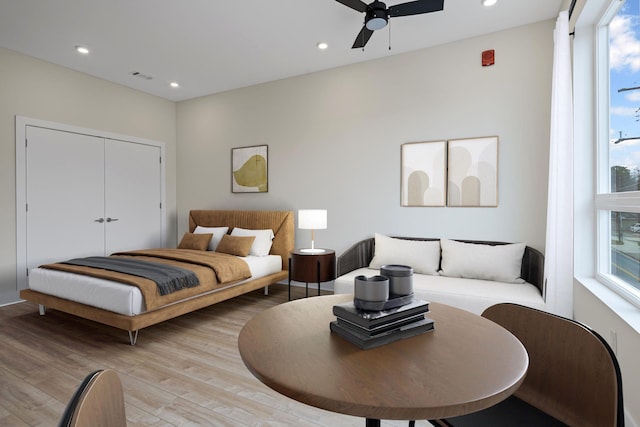 bedroom featuring multiple windows, light hardwood / wood-style flooring, and ceiling fan