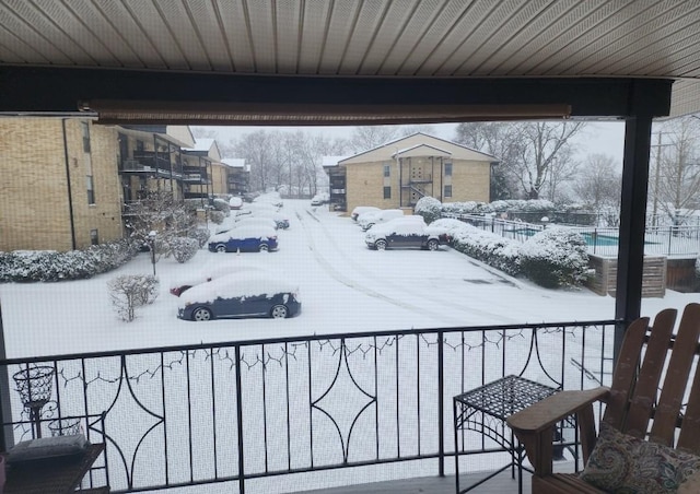 view of snow covered back of property