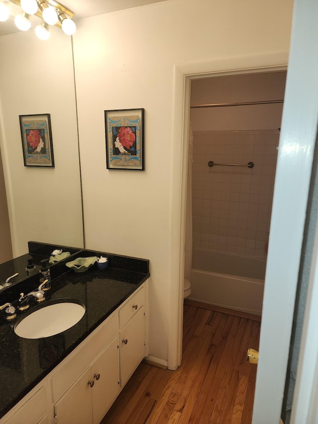 full bathroom with shower / bath combination with curtain, wood-type flooring, toilet, and vanity