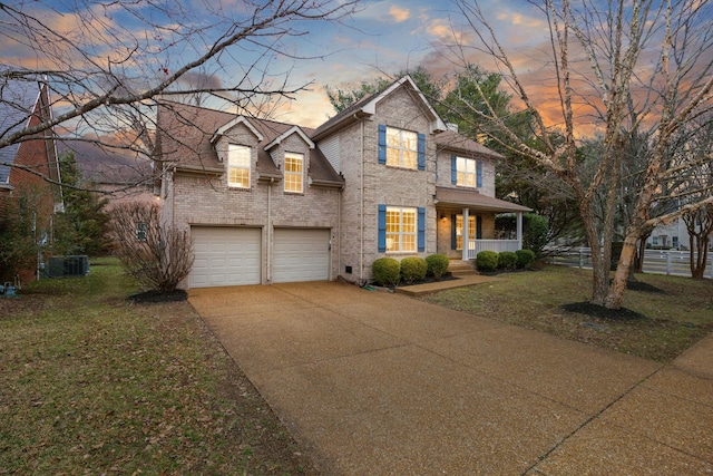 view of front facade with a porch, a garage, and a yard