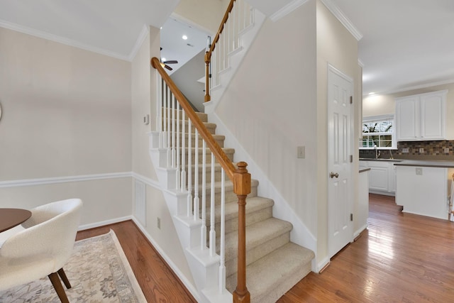 stairs featuring ornamental molding and hardwood / wood-style floors