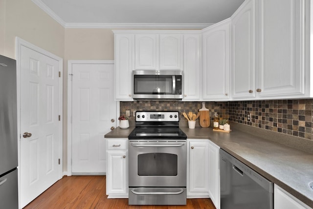 kitchen with decorative backsplash, ornamental molding, white cabinets, and appliances with stainless steel finishes