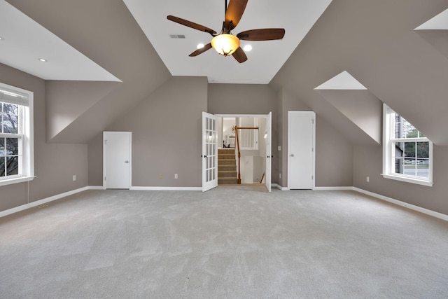 additional living space with a wealth of natural light, light colored carpet, and vaulted ceiling