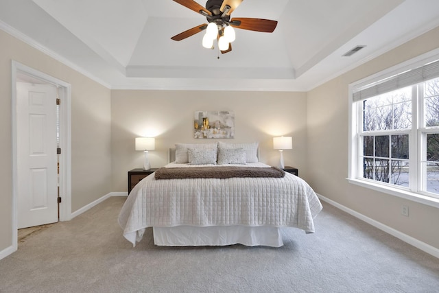 bedroom featuring light carpet, crown molding, a raised ceiling, and ceiling fan