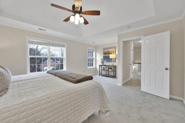 bedroom with ceiling fan, ornamental molding, a raised ceiling, and light carpet