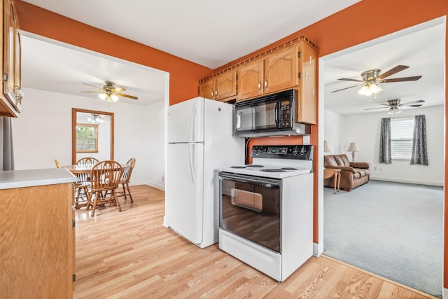 kitchen featuring white refrigerator, light wood-type flooring, and electric stove