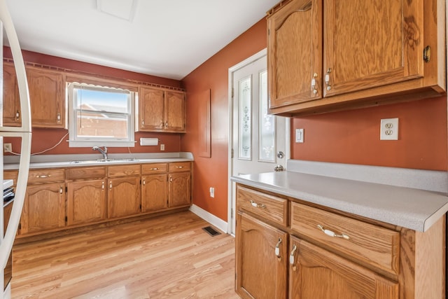 kitchen with stove, sink, and light hardwood / wood-style flooring