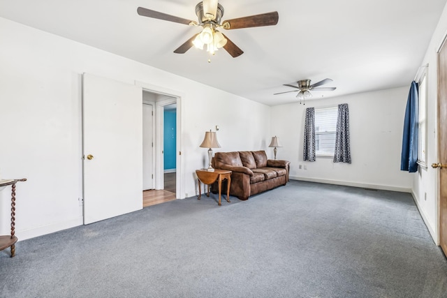 sitting room with ceiling fan and dark carpet