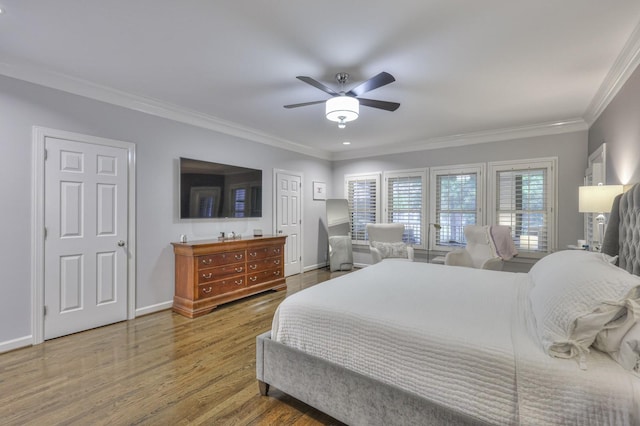 bedroom with baseboards, wood finished floors, a ceiling fan, and crown molding